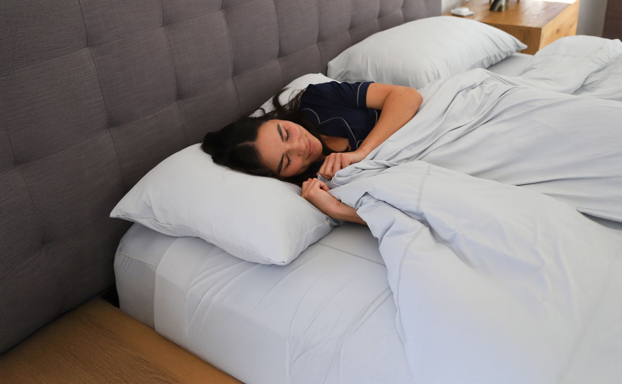 Woman sleeping in SHEEX bedding and sleepwear