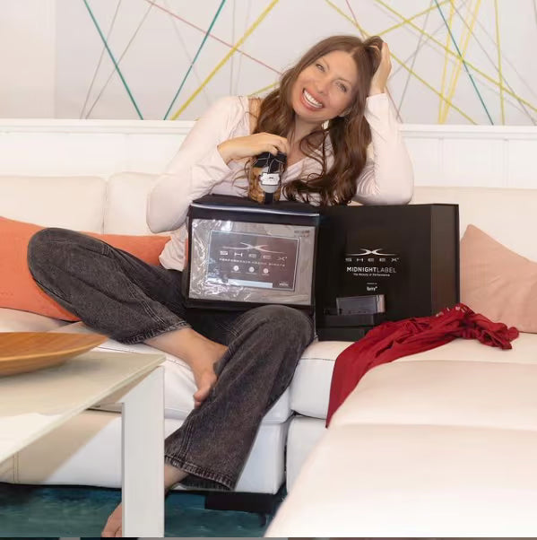 Woman sitting on a couch with a SHEEX box in front of her.