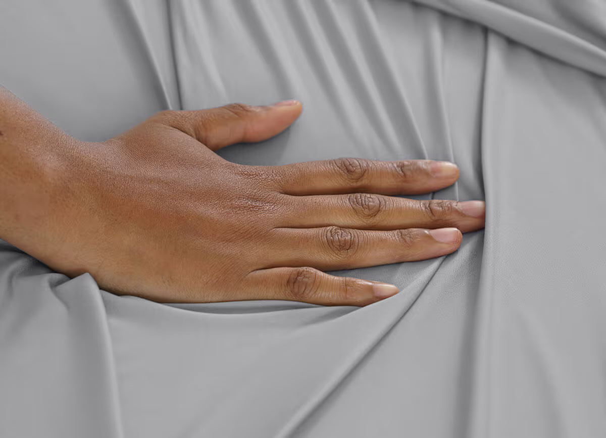 Hand touching gray fabric
