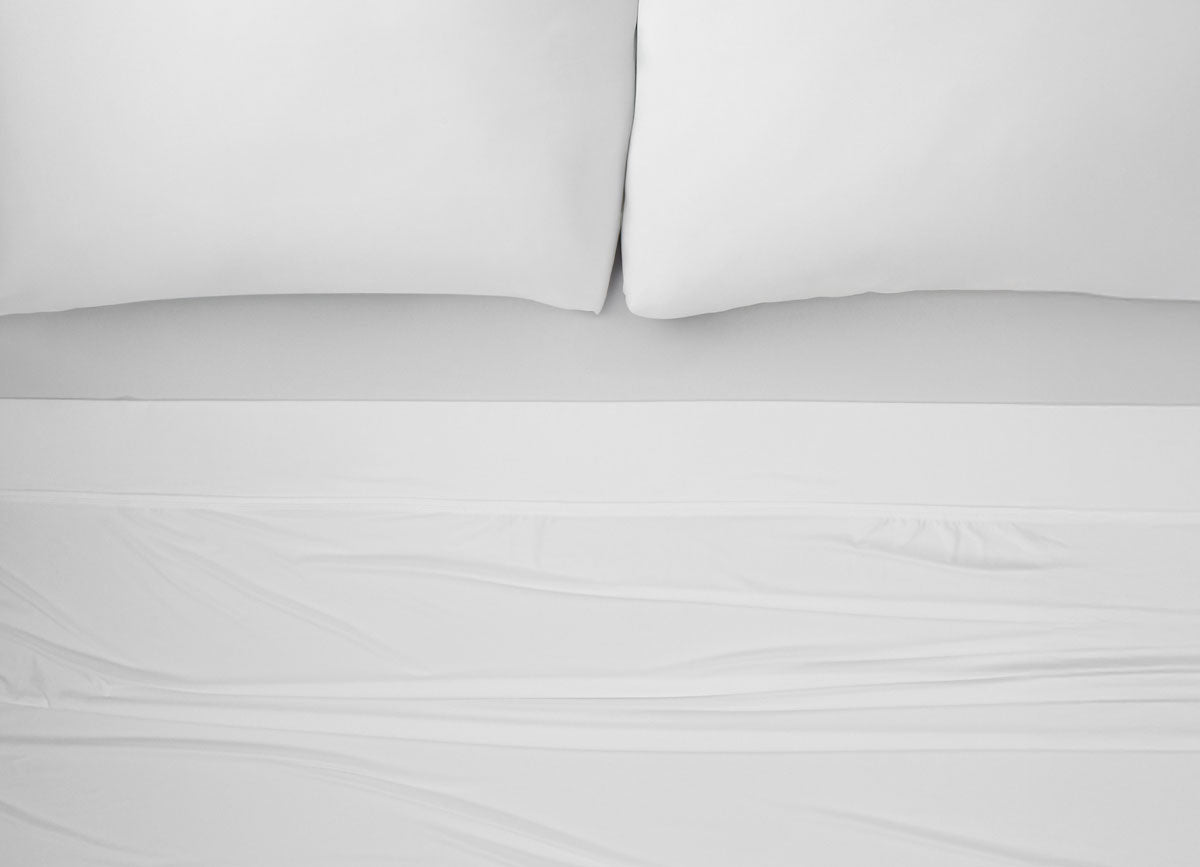 Nightfall Sheets and Pillowcases on a bed shown in Cloud White #choose-your-color_cloud-white