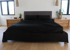 Black sheet set shown on bed in bedroom environment. #choose-your-color_black