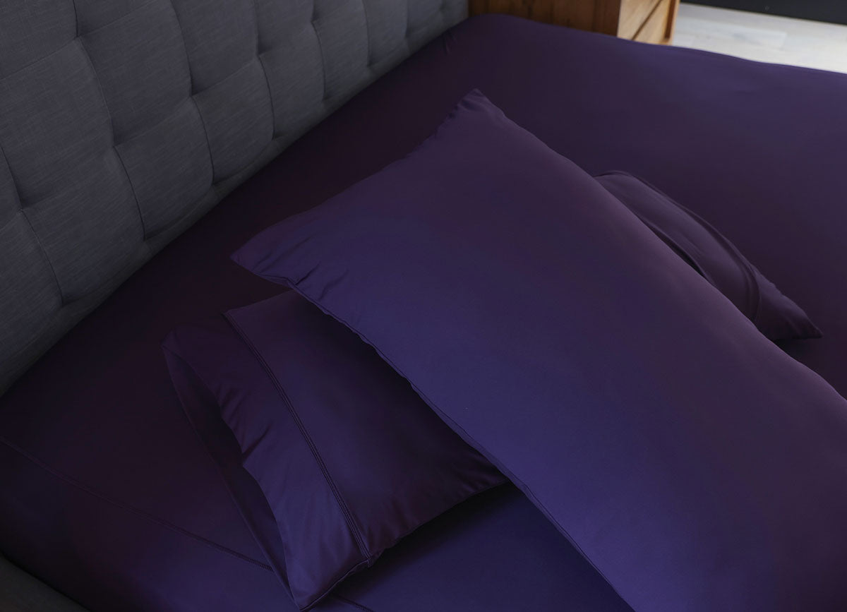 Royal Plum pillowcases shown on bed in bedroom environment. #choose-your-color_royal-plu