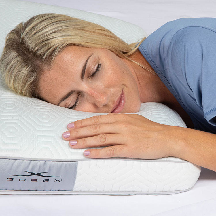 Woman laying on INFINITE ZEN Pillow looking happy
