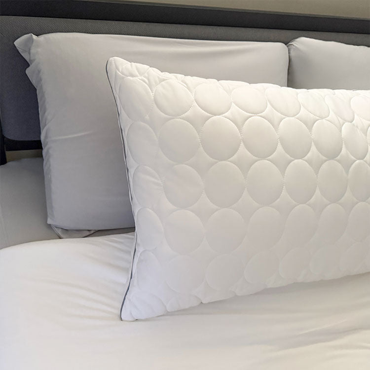 White Nightfall body pillow shown on a bed with other nightfall products.