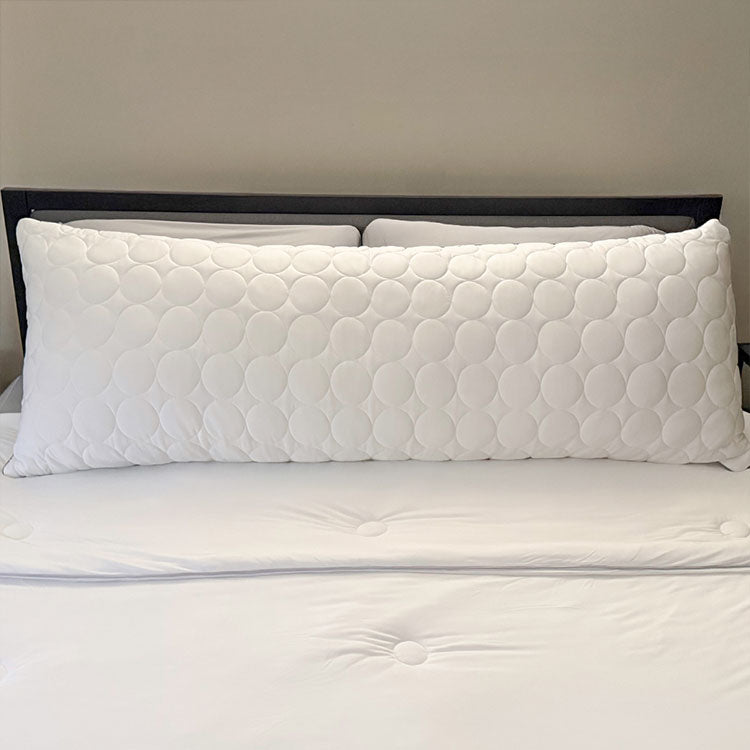 White Nightfall body pillow shown on a bed with other nightfall products.
