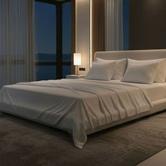 Modern bedroom with a large bed, nightstands, and a lamp near a window with curtains. Bed has Nightfall Sheet Sets in Cloud White color.#choose-your-color_cloud-white