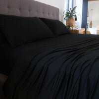 Black sheet set shown on bed in bedroom environment. #choose-your-color_black