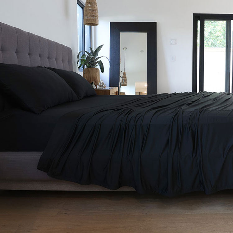 Black sheet set shown on bed in bedroom environment. #choose-your-color_black