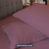 Cherry Blossom pillowcase set shown on bed in bedroom environment. #choose-your-color_cherry-blossom