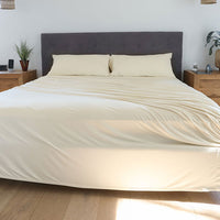 Ecru sheet set shown on bed in bedroom environment. #choose-your-color_ecru
