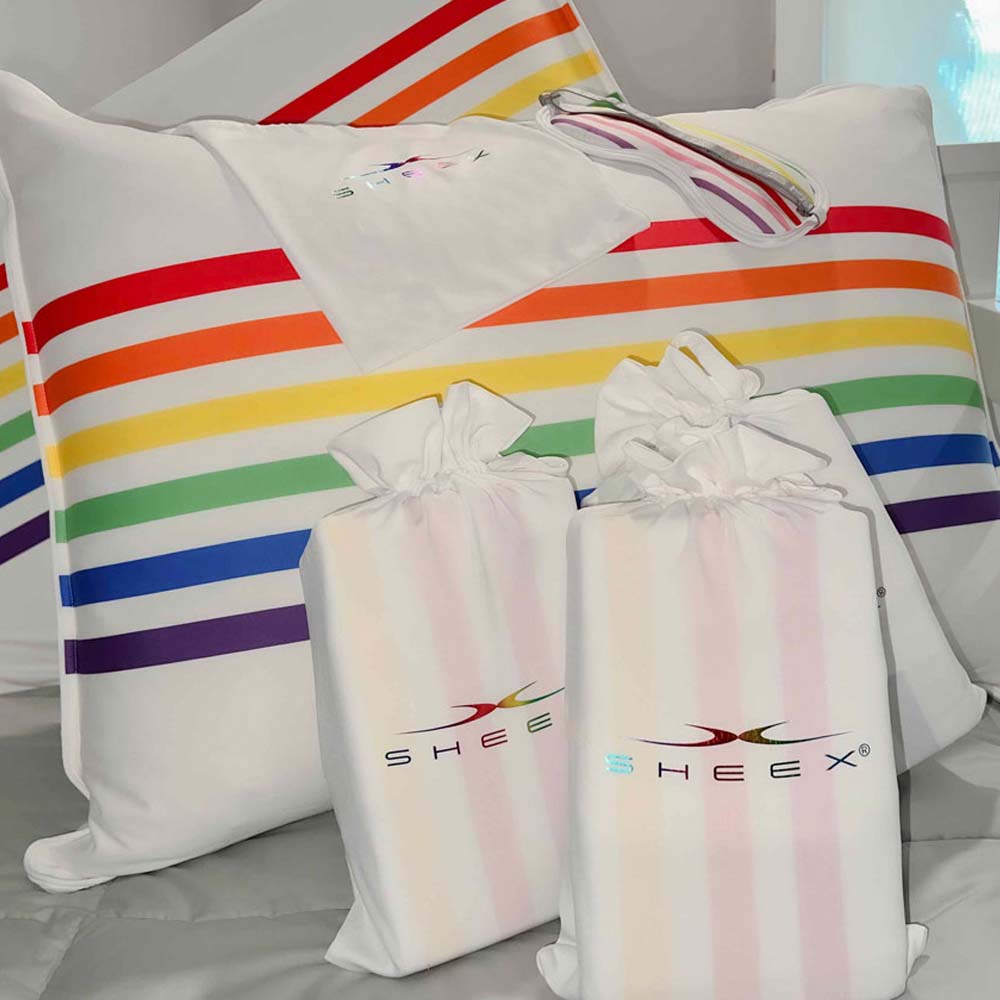 Pride pillow shams, eye mask and pouch on bed.