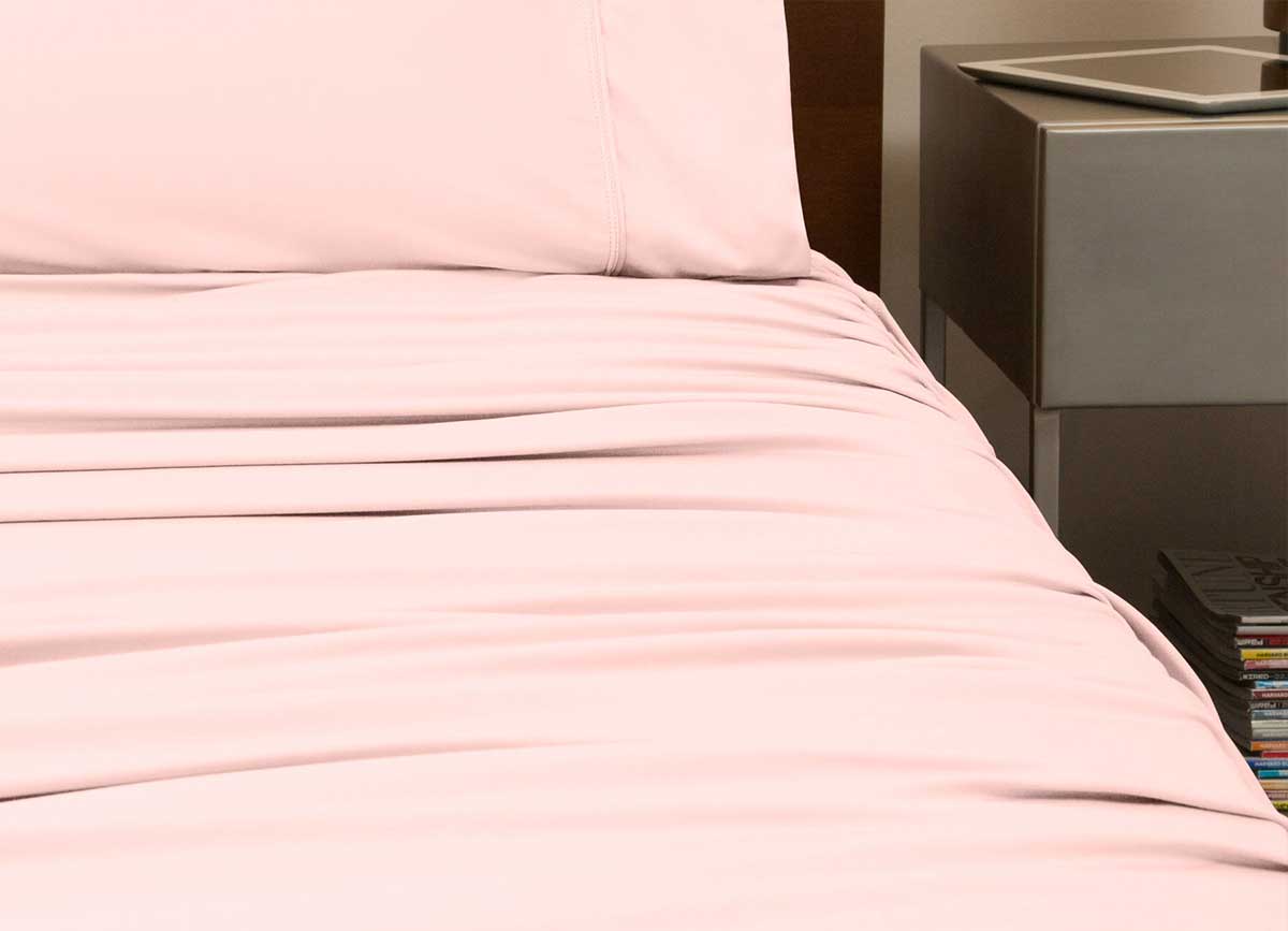 reNEWed Sheet Set on bed in room environment, Blush Pink #choose-your-color_blush-pink
