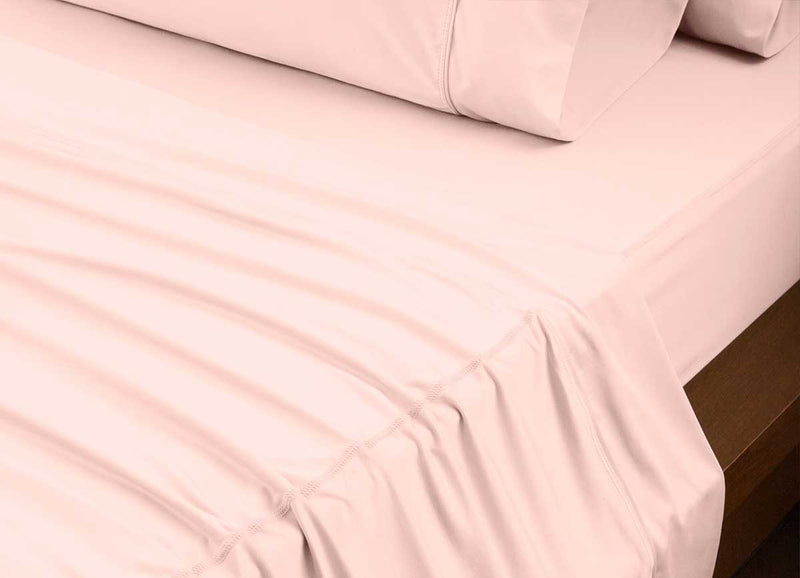 reNEWed Sheet Set on bed in room environment, Blush Pink #choose-your-color_blush-pink