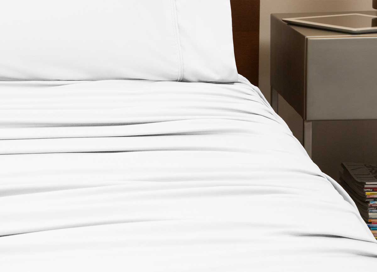 reNEWed Sheet Set on bed in room environment, Bright White #choose-your-color_bright-white