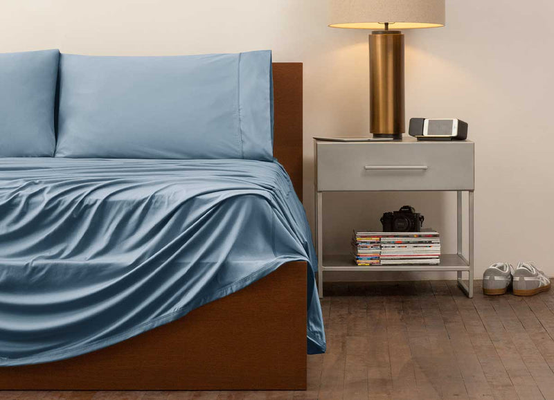 reNEWed Sheet Set on bed in room environment, Carolinia Blue #choose-your-color_carolina-blue
