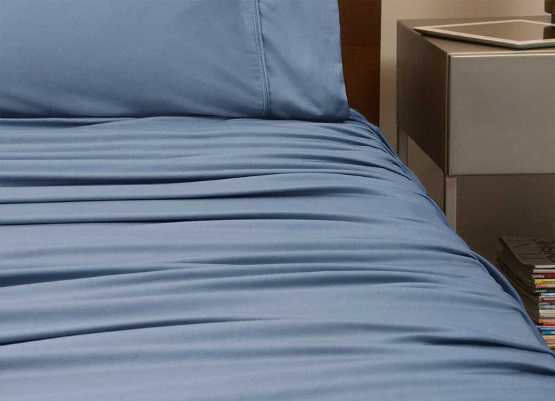reNEWed Sheet Set on bed in room environment, Carolinia Blue #choose-your-color_carolina-blue