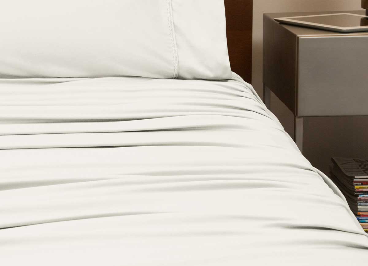 reNEWed Sheet Set on bed in room environment, Ecru #choose-your-color_ecru
