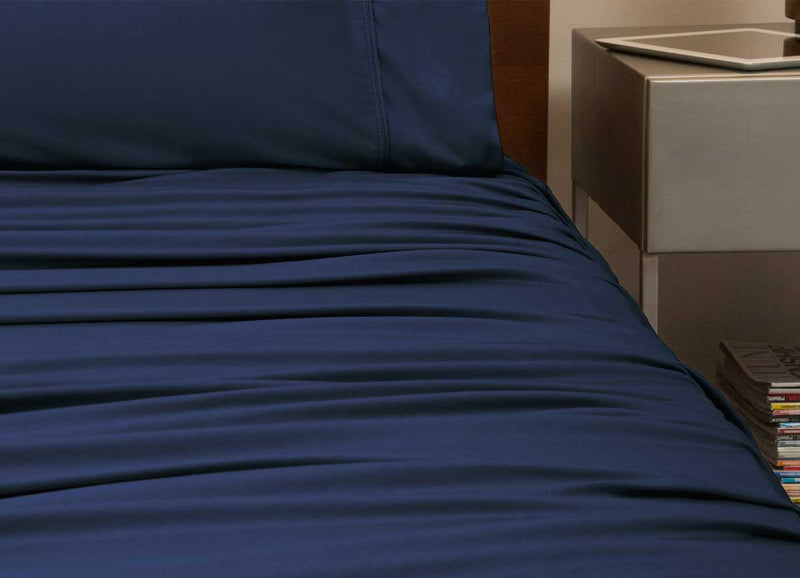 reNEWed Sheet Set on bed in room environment, Navy #choose-your-color_navy